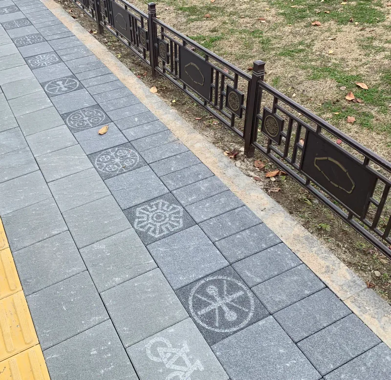 풍납토성 보도 문양 블록 줄. 회색 블록 사이에 원형·꽃 모양 옛 문양과 자전거 그림이 새겨진 블록이 전통 난간을 따라 이어진다.
