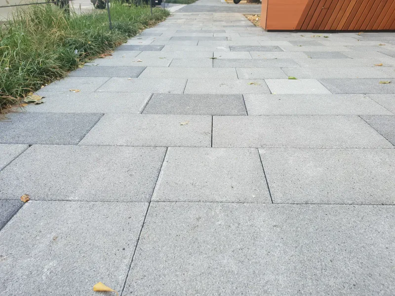 중구 동호로 목재 화분 벤치 앞 보도. 회색 대형 블록 사이에 짙은 회색 블록이 끼어 있고 넓은 줄눈이 가지런하다.