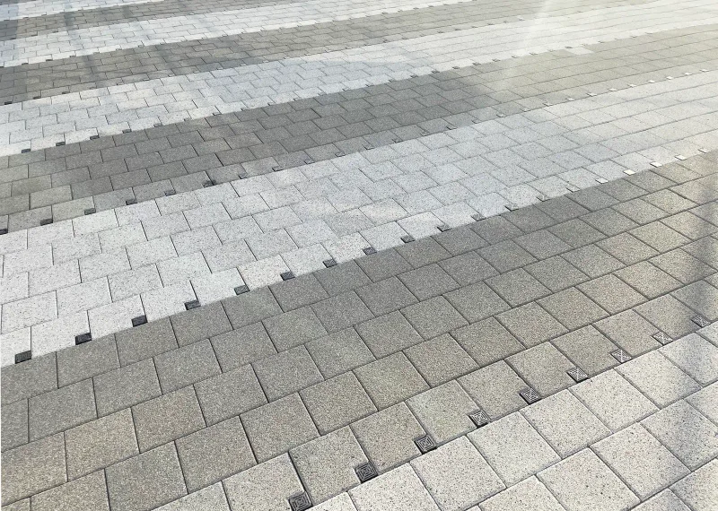 중곡 보건복지행정타운 보행로 블록 근접 사진. 짙은 회색과 밝은 회색 직사각형 블록이 넓은 띠로 교차하며 표면 질감이 드러난다.