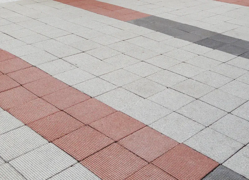 숭실대학교 중문 앞 블록 표면 근접. 연회색 블록 바닥을 적갈색 블록 두 줄과 짙은 회색 블록 한 줄이 사선으로 가로지른다.