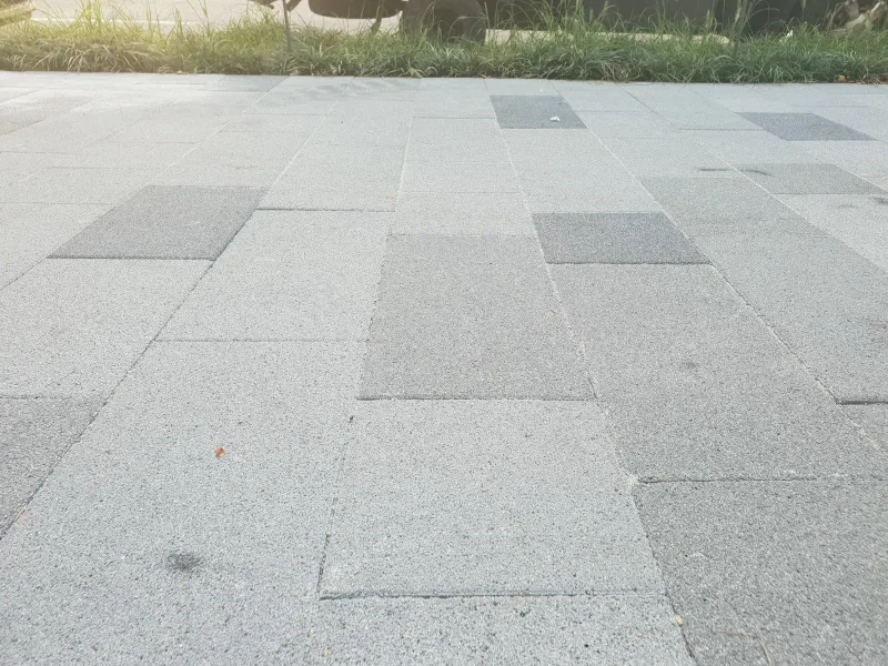 중구 동호로 보도 표면 근접. 화강석 느낌의 밝은 회색 대형 블록과 짙은 회색 블록이 넓게 어긋나게 깔린 질감이 보인다.