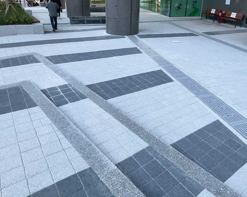 구리 유탑유블레스 오피스텔 전면 경사로 주변. 연회색 블록 사이로 짙은 회색 블록 띠와 화강석 경계 띠가 계단 모양으로 엇갈려 깔려 있다.