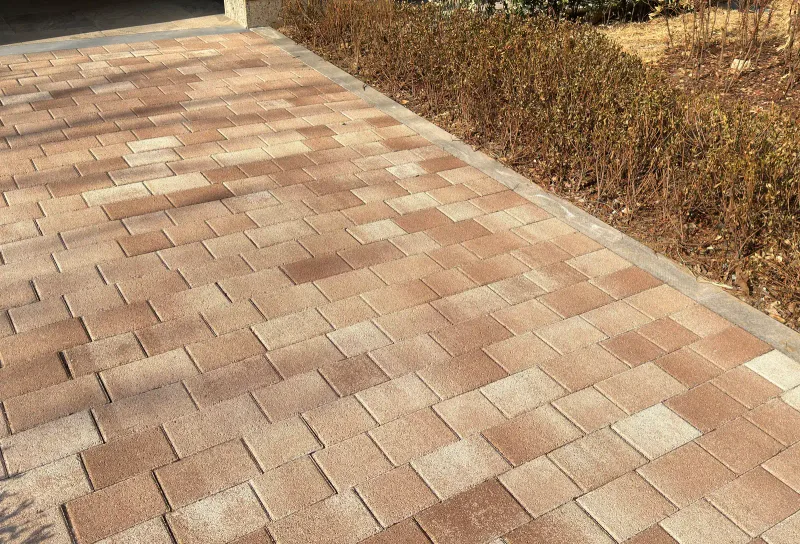 잠실 르엘 화단 옆 포장면. 적갈색·분홍·베이지 블록을 섞어 깐 바닥이 넓게 보이고 가장자리는 회색 경계석으로 마감했다.